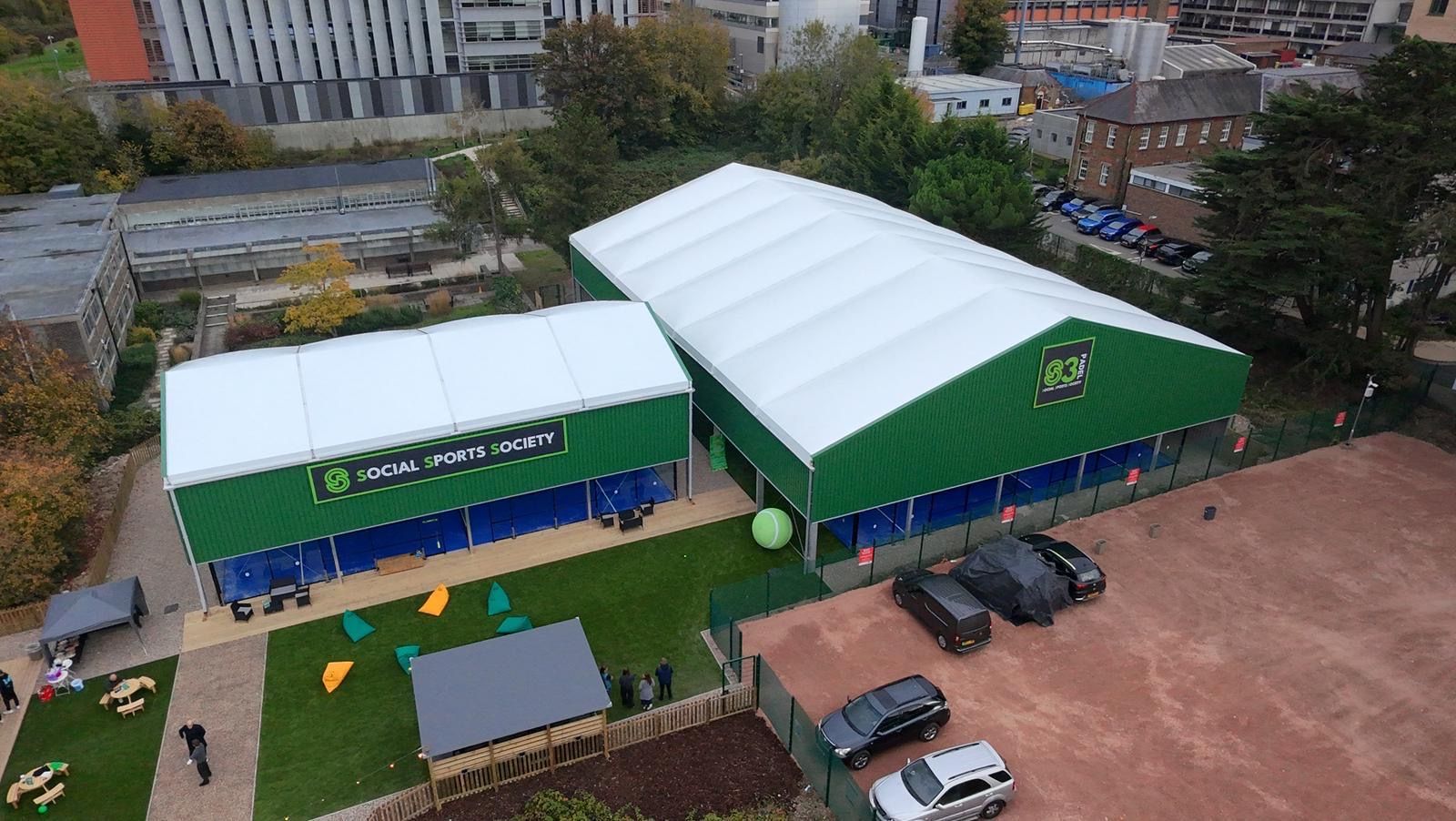 Covered courts and social lawn — example padel site